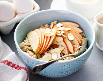 Oatmeal Bowl Topped with Apple Slices and Almonds at Assisted Living Facility Oatmeal Bowl Topped with Apple Slices and Almonds at Assisted Living Facility