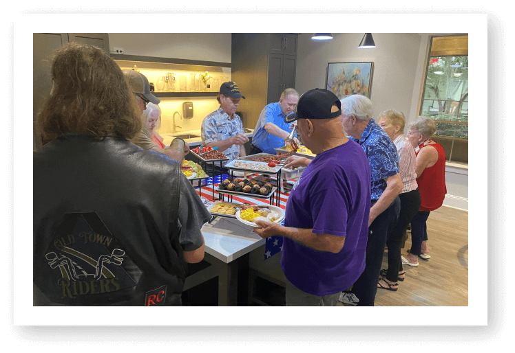 Residents and Guests Enjoying Buffet Meal Together at Assisted Living Facility