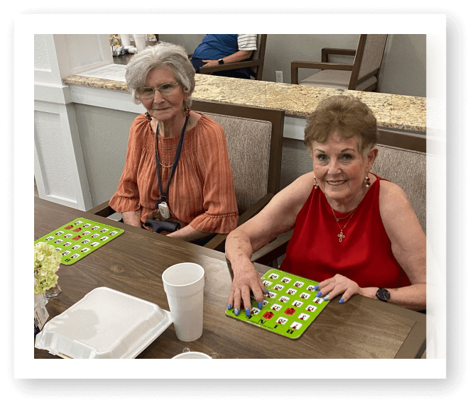 Two Elderly Women Playing Bingo Together at Assisted Living Facility