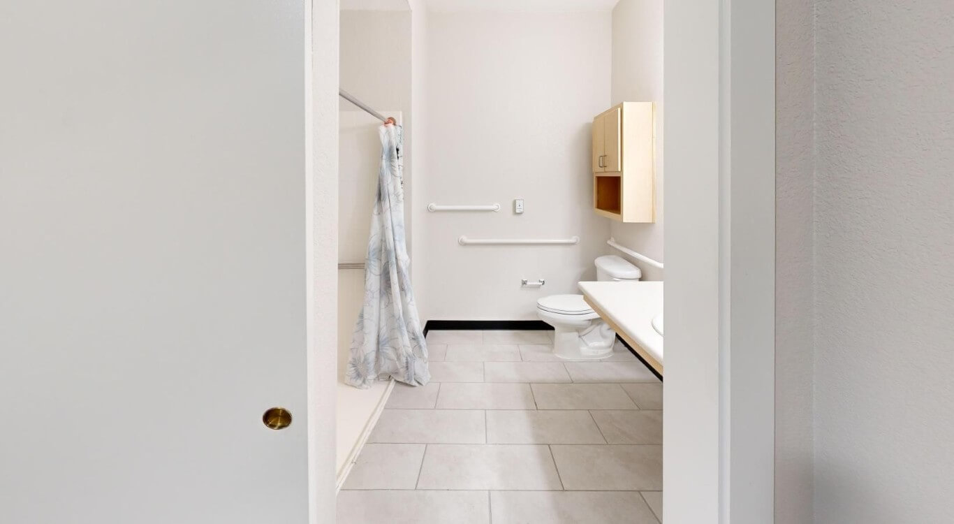 Accessible Bathroom with Grab Bars and Walk-in Shower at Assisted Living Facility