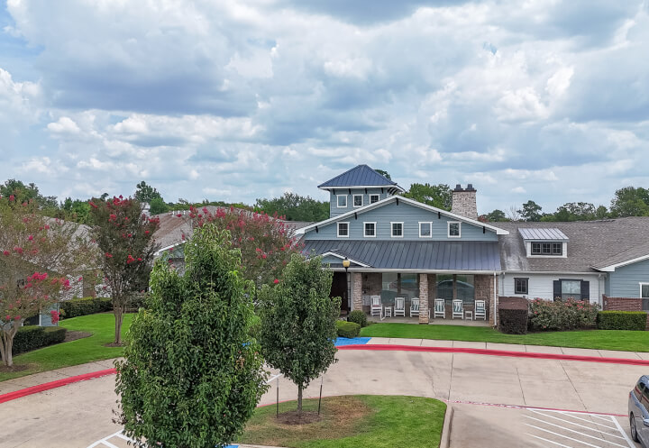 Exterior Building with Front Porch and Rocking Chairs at Assisted Living Facility Exterior Building with Front Porch and Rocking Chairs at Assisted Living Facility