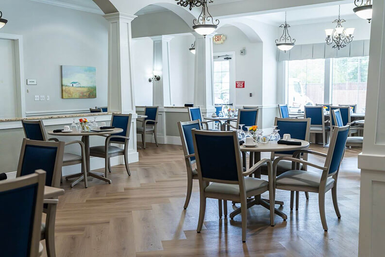 Formal Dining Room with Blue Chairs and Chandeliers at Assisted Living Facility Formal Dining Room For Seniors in Assisted Living Facility