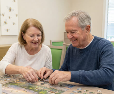 Elderly Couple Working on Puzzle Together at Assisted Living Facility Elderly Couple Working on Puzzle Together at Assisted Living Facility