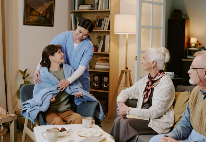 Female Nurse Offering a Comfort Blanket to a Senior Woman in Memory Care Female Nurse Offering a Comfort Blanket to a Senior Woman in Memory Care