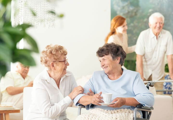 Senior Women Socializing Over Tea in the Broad Daylight of a Memory Care Facility Senior Women Socializing Over Tea in the Broad Daylight of a Memory Care Facility